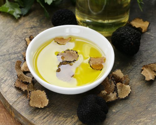 Huile d'olive aromatisée à la truffe noire sur une table en boisHuile d'olive aromatisée à la truffe noire sur une table en bois - Visit Provence
